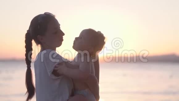 妈妈亲吻并拍拍她的金发小宝宝视频的预览图