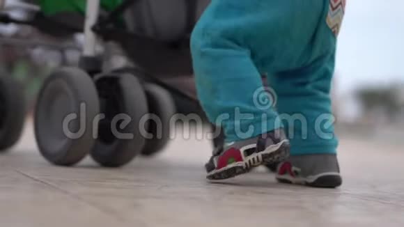 慢动作婴儿车附近小孩和母亲的腿视频的预览图