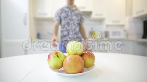不可辨认的人从盘子里拿出新鲜干净的苹果吃视频的预览图