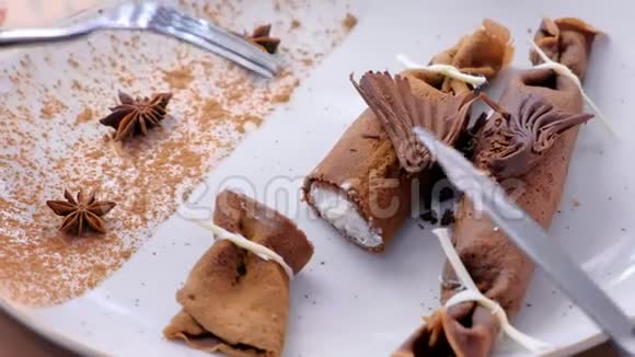 女人正在吃俄式巧克力薄饼在盘子里用豆腐馅双手特写提供茶视频的预览图