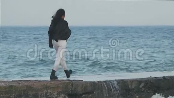 戴太阳镜的亚洲女孩在海边1风把一个头发花白的女孩吹到了海边的码头视频的预览图