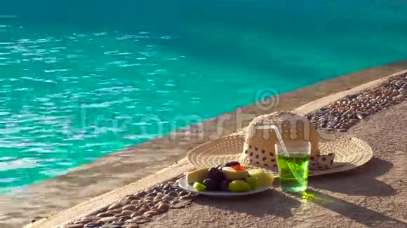 盘子里有异国情调的水果和游泳池留下的饮料所有包容性视频的预览图