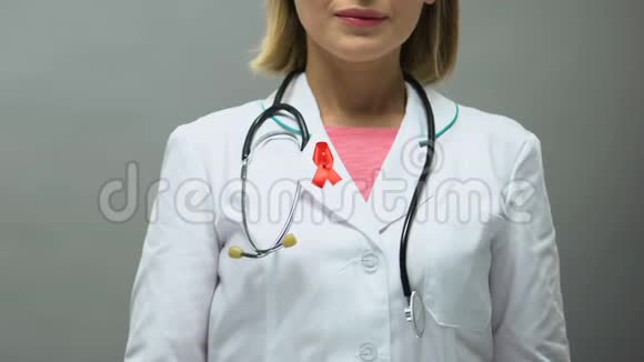 带红色丝带的女医生为相机艾滋病意识性病视频的预览图