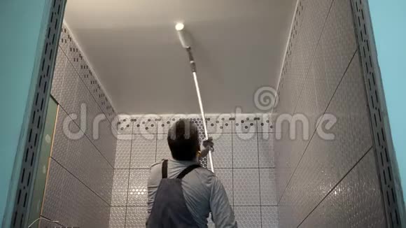 工人油漆浴室天花板与滚筒工具视频的预览图