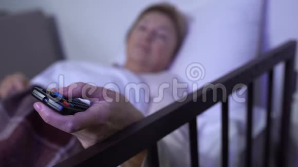 躺在病床上的妇女在电视上转换频道在医院的个人病房视频的预览图