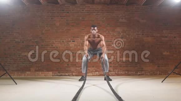肌肉非洲男子训练与绳索在健身房的功能训练慢动作视频的预览图