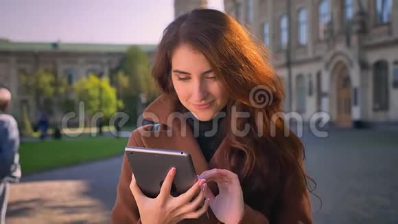 美丽的白种人女人正在擦拭她的平板电脑然后在相机上显示绿色屏幕就像用标牌演示一样视频的预览图