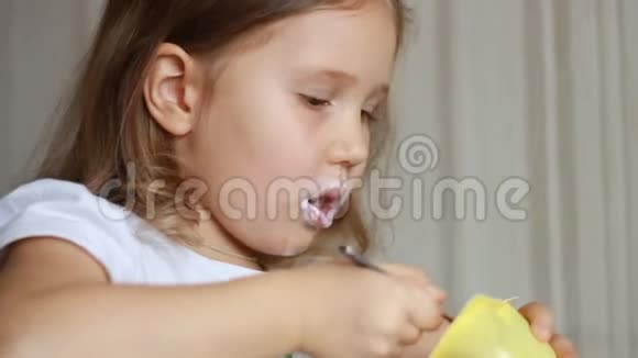 小女孩吃乳制品酸奶小孩用勺子吃奶酪视频的预览图