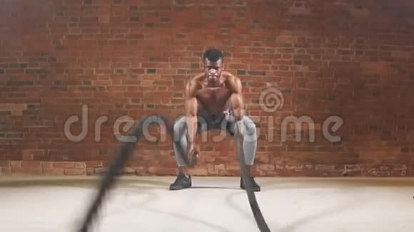 美国黑人运动员在健身房的功能训练中用绳子管理慢动作视频的预览图