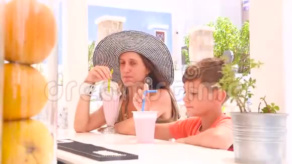 男孩和他母亲坐在酒吧里视频的预览图