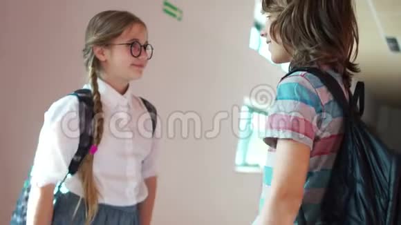 小学生一个女孩和一个男孩在学校走廊里说话笑着困惑着初恋学校友谊视频的预览图