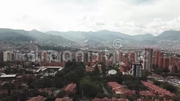 向后飞行的无人机在哥伦比亚麦德林市的鸟瞰图显示了城市景观和地区视频的预览图