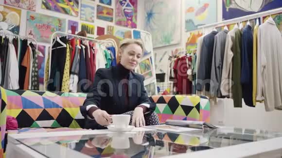 成年女商人喝咖啡读杂志视频的预览图