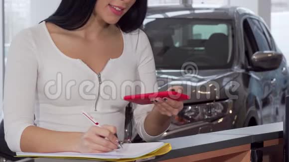 使用智能手机的女性客户签署新汽车的文件视频的预览图