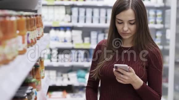 带电话的年轻女士在商店里购物视频的预览图