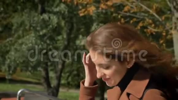 从白种人背后拍摄的美丽的黑发女子正在绿色阳光公园户外城市背景和视频的预览图