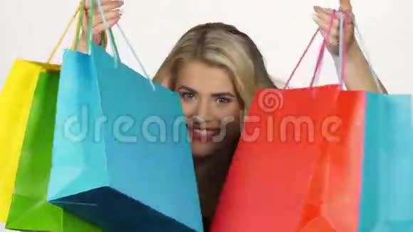 漂亮的女孩带着五颜六色的包裹购物白色视频的预览图