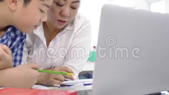 多莉拍摄的亚洲家庭母子一起在手机上玩游戏的笑脸视频的预览图