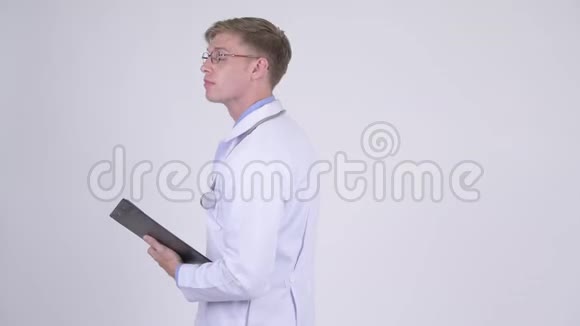快乐的年轻帅哥医生拿着剪贴板挥舞着手视频的预览图