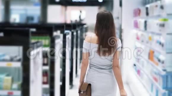 背面风景女孩在化妆品商店购物带篮子慢动作视频的预览图