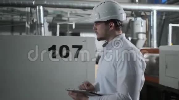 职业工厂工人戴着硬帽子的平板电脑被射杀行走在现代工业中视频的预览图