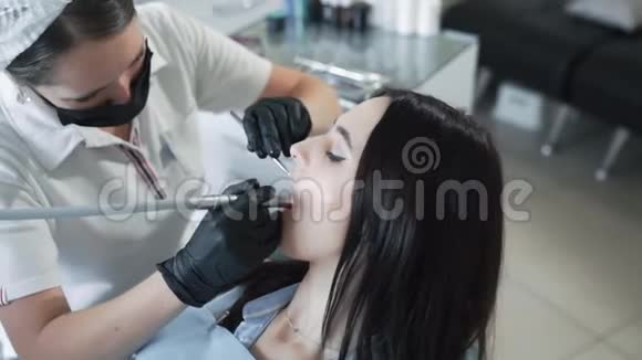 牙医向年轻女子钻牙动作缓慢牙科治疗的概念视频的预览图