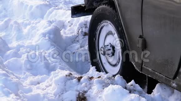 一辆被困在雪地里的汽车使车轮转动视频的预览图
