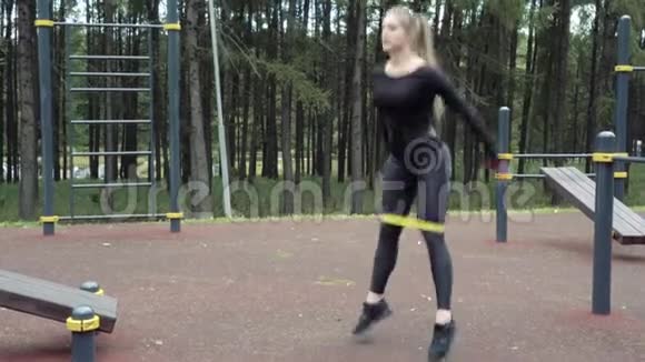 年轻女子在户外做弹性带运动视频的预览图