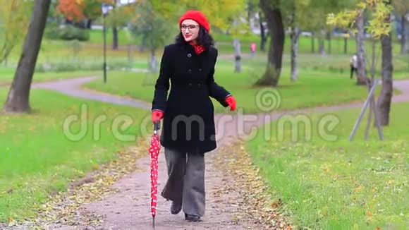 秋天公园里的女人带着红伞跳舞视频的预览图