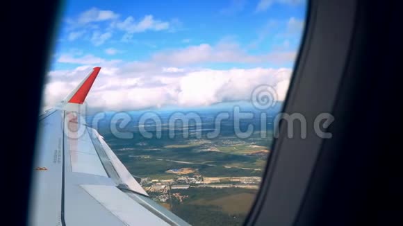透过飞机窗户观看蓝天和云彩带有飞机机翼的飞机窗户特写视频的预览图