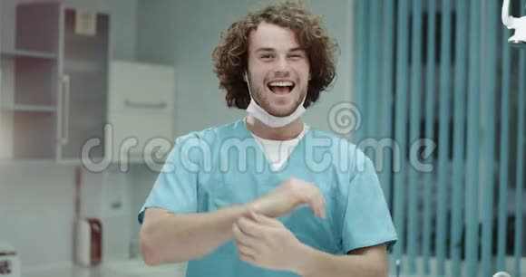 快乐的年轻医生或外科医生在医院里快乐地向镜头展示他心情愉快笑容满面视频的预览图