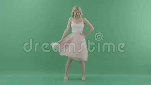 漂亮的金发女人穿着白色衣服在绿色背景下摆姿势视频的预览图