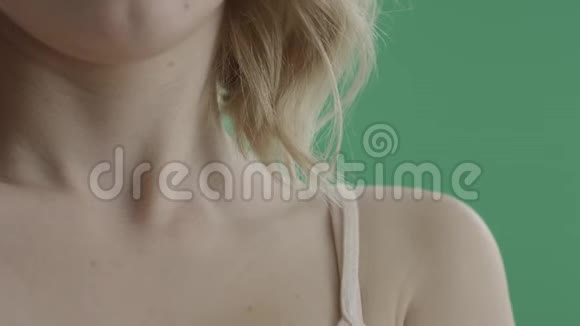 年轻漂亮的女人在绿色的屏幕上抚摸你的肩膀和脖子视频的预览图