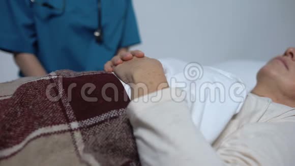 主治医生抚摸女性病人的手支持她临终关怀视频的预览图