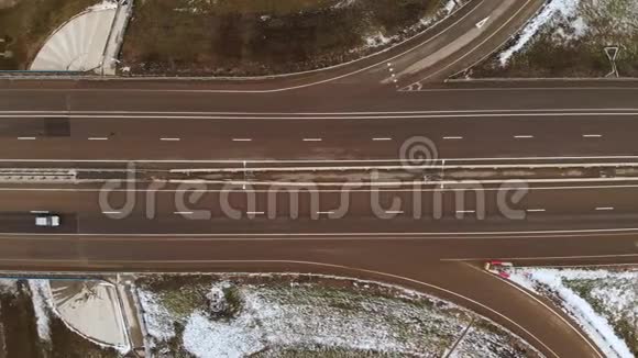 空中拍摄的汽车和卡车在一个冬季十字路口与一个大的道路交叉口的顶部视图无知的观点视频的预览图