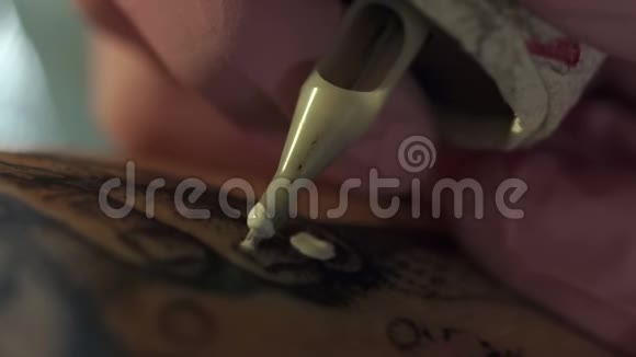 在年轻女孩腿上做纹身的纹身艺术家的特写镜头视频的预览图
