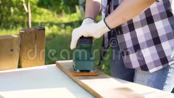 戴防护手套的女士双手用旧木板打磨视频的预览图
