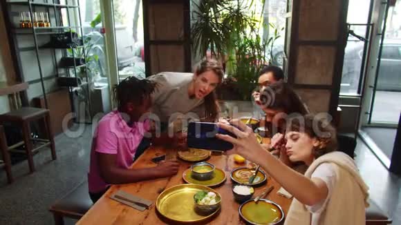多元文化的朋友坐在咖啡馆里女孩合影视频的预览图