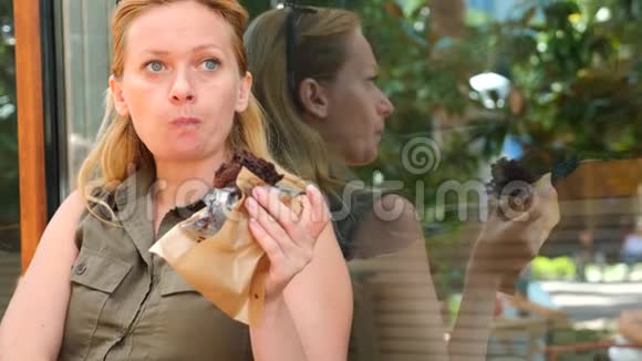 一个胖女人在咖啡馆里吃一个小蛋糕然后啜饮咖啡4k慢动作视频的预览图