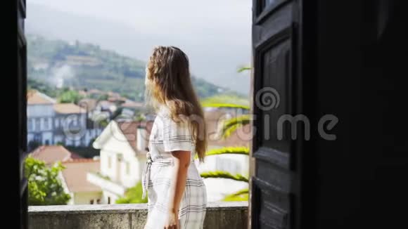 在葡萄牙别墅阳台上散步的漂亮女孩视频的预览图