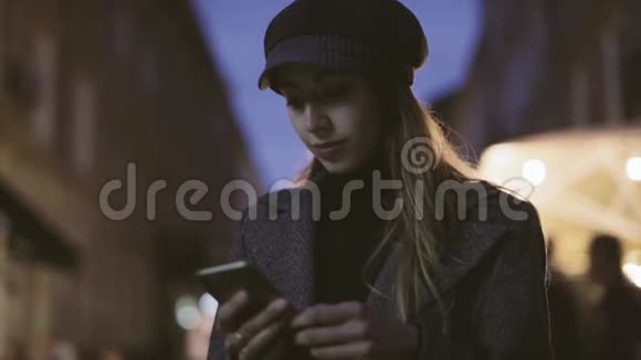 年轻漂亮时髦的黑发女人晚上站在街上用电话的肖像模特穿着视频的预览图