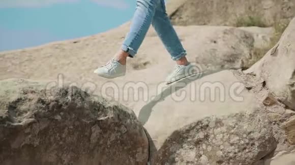 年轻苗条的女孩穿着短牛仔裤和白色运动鞋独自走在佐治亚州的岩石上视频的预览图