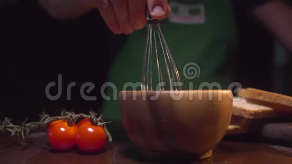 厨师用搅拌器搅拌碗里的酱汁男人在厨房做饭配料做酱汁做酱汁视频的预览图