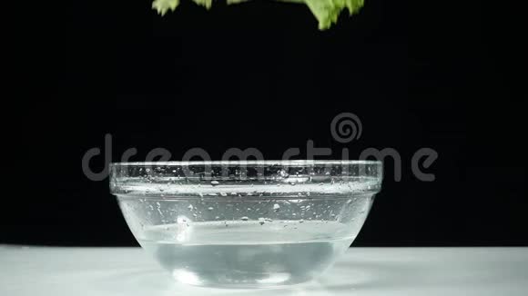 莴苣叶慢慢地掉进一杯水里健康美味健康的食物视频的预览图