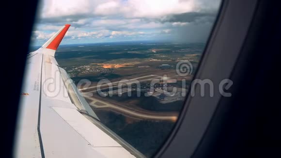 透过飞机窗户观看蓝天和云彩带有飞机机翼的飞机窗户特写视频的预览图