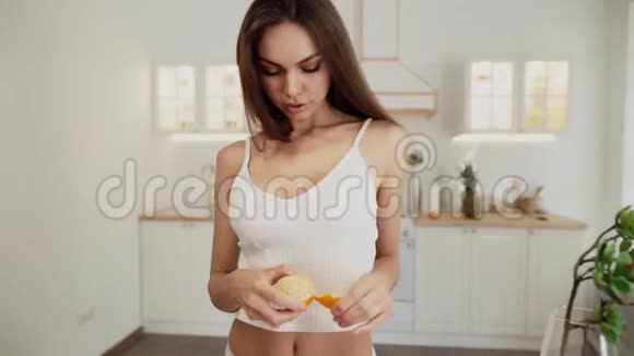 穿着白色内衣的漂亮性感女人吃橘子视频的预览图