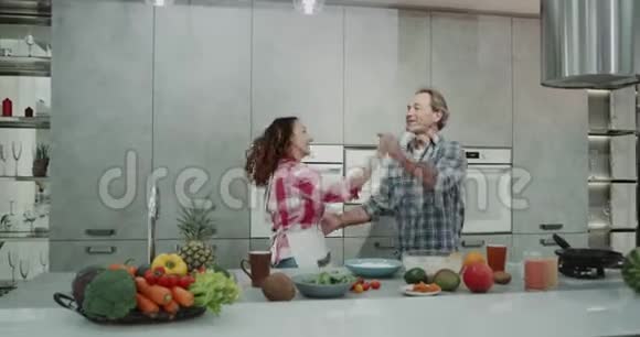 在现代的厨房里成熟的夫妇在一起度过浪漫的时光同时烹饪他们的食物非常有魅力视频的预览图