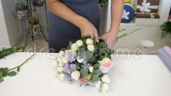 女花匠用玫瑰果蝇和树叶特写手做花束视频的预览图