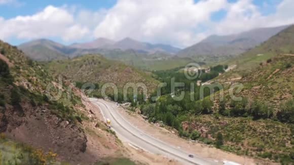 乌兹别克斯坦山脉之间的道路群山中的春绿视频的预览图