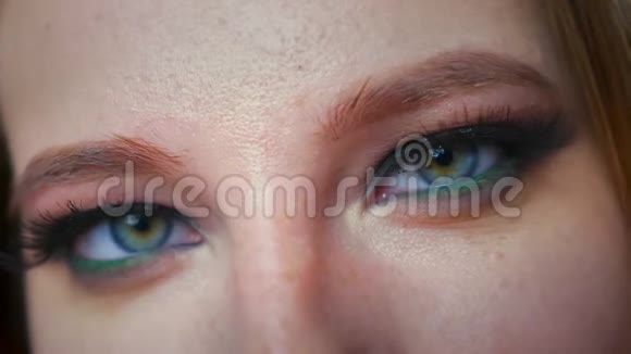 白种人女性美丽的蓝绿色眼睛集中看镜头在室内展示美丽的化妆品视频的预览图